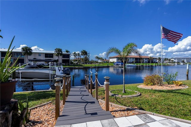 view of dock with a water view and a lawn