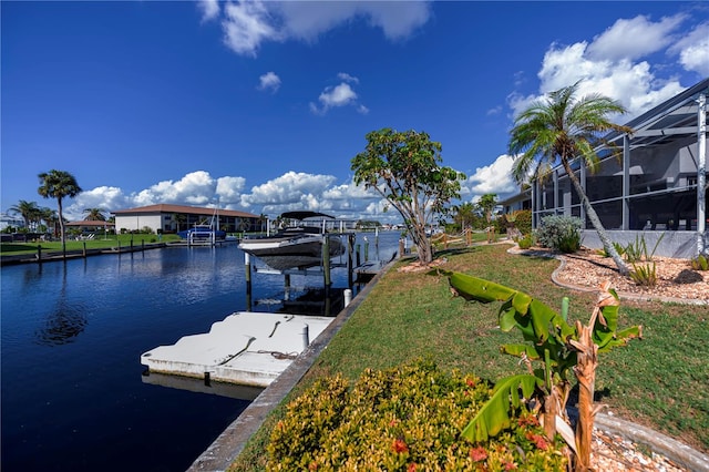 dock area with a water view, glass enclosure, and a yard