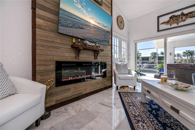 living area with french doors, marble finish floor, and a glass covered fireplace