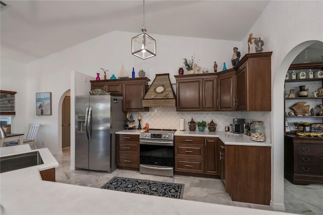 kitchen featuring premium range hood, arched walkways, stainless steel appliances, vaulted ceiling, and marble finish floor