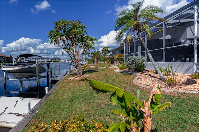 dock area with a yard, a water view, boat lift, and a lanai