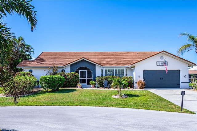 view of front of home with stucco siding, a front lawn, concrete driveway, an attached garage, and a tiled roof