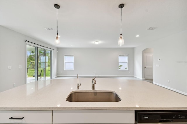 kitchen featuring light stone counters, black dishwasher, sink, pendant lighting, and white cabinetry