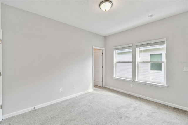 unfurnished room featuring light carpet