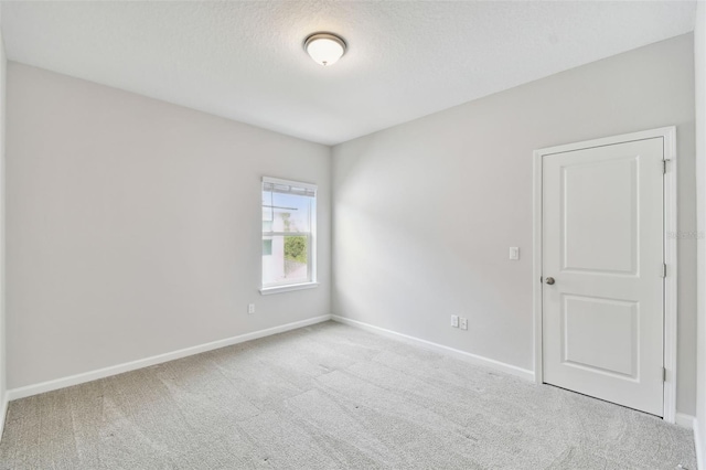 carpeted empty room featuring a textured ceiling