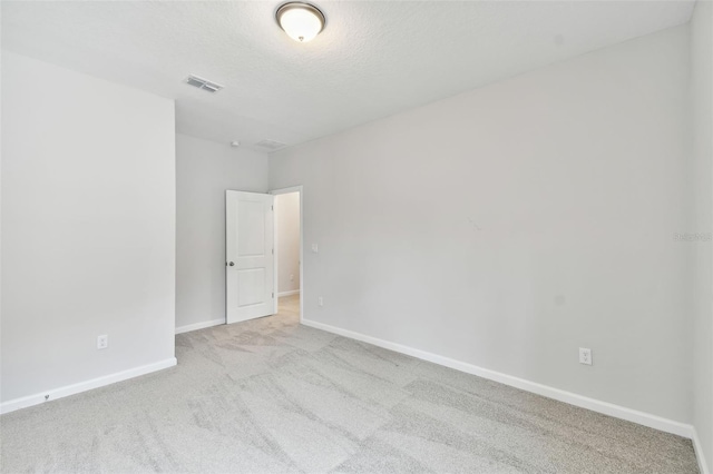 carpeted empty room featuring a textured ceiling