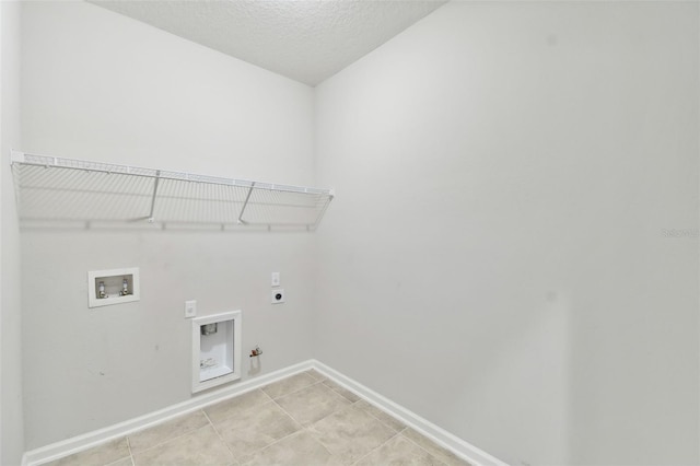 clothes washing area featuring washer hookup, a textured ceiling, light tile patterned floors, electric dryer hookup, and hookup for a gas dryer