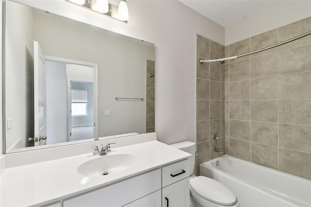 full bathroom featuring toilet, tiled shower / bath combo, and vanity