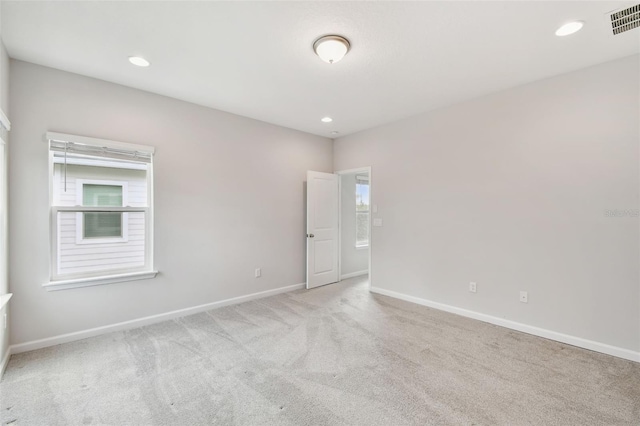 empty room with a wealth of natural light and light colored carpet