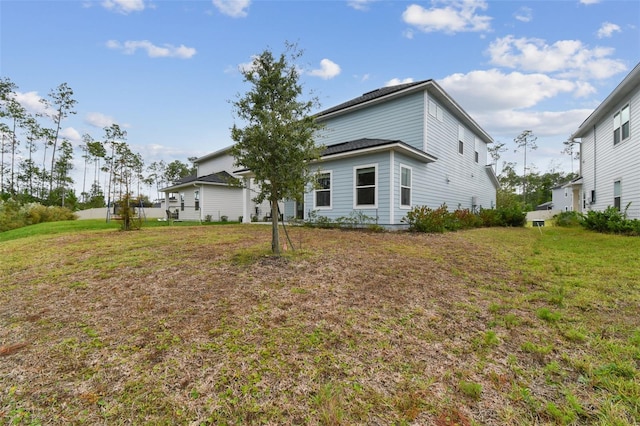 rear view of property featuring a lawn