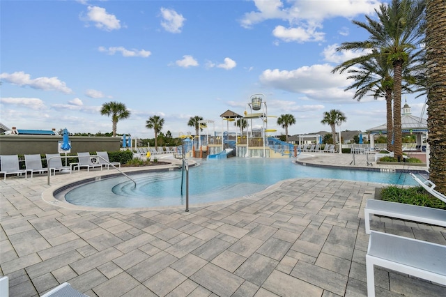 view of swimming pool featuring a patio and a playground