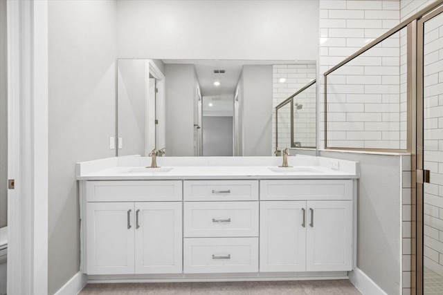 bathroom featuring vanity, toilet, and a shower with shower door