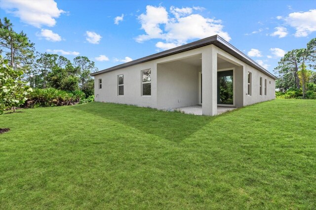 back of property with a patio area and a lawn