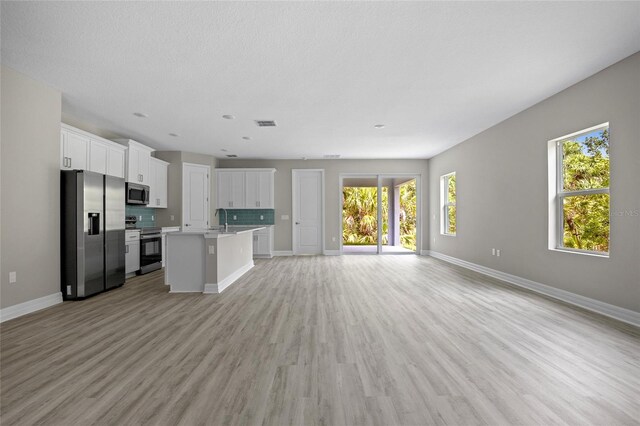3883 Dominic St, North Port, FL 34288 - unfurnished living room featuring baseboards, visible vents, a sink, and light wood-type flooring