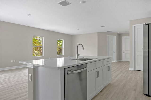 3883 Dominic St, North Port, FL 34288 - kitchen with a kitchen island with sink, baseboards, a sink, light wood-style flooring, and appliances with stainless steel finishes