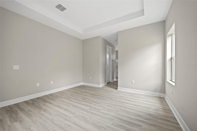 3883 Dominic St, North Port, FL 34288 - spare room featuring baseboards, light wood-type flooring, a raised ceiling, and visible vents