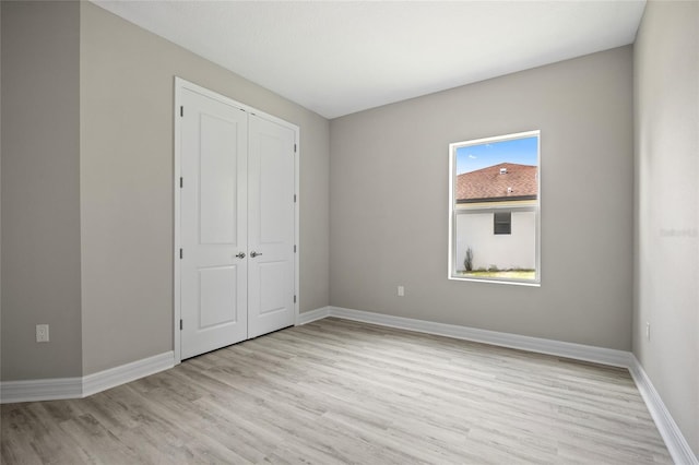 3883 Dominic St, North Port, FL 34288 - unfurnished bedroom with baseboards, wood finished floors, and a closet