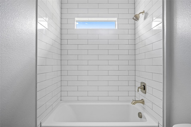 3883 Dominic St, North Port, FL 34288 - bathroom featuring shower / bath combination, a textured wall, and toilet