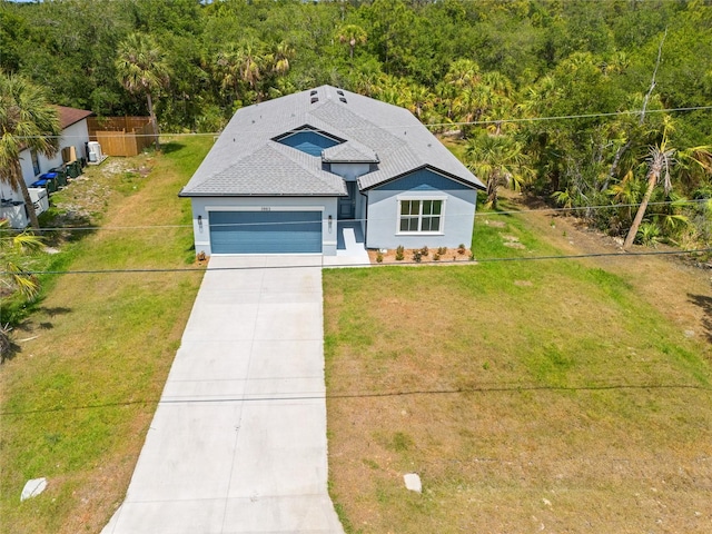 3883 Dominic St, North Port, FL 34288 - bungalow with fence, roof with shingles, a garage, stucco siding, and driveway