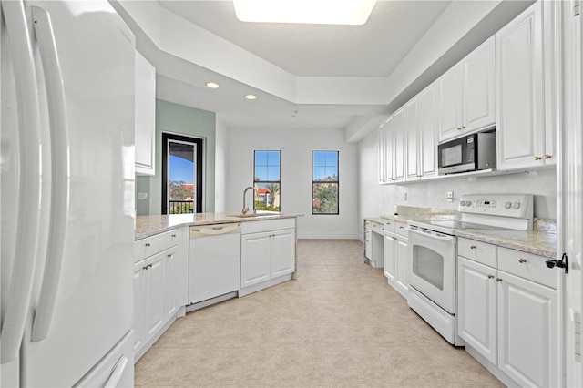 kitchen featuring sink, light tile patterned flooring, kitchen peninsula, white appliances, and white cabinets