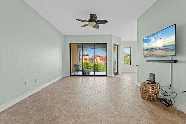 unfurnished living room featuring light tile patterned floors and ceiling fan