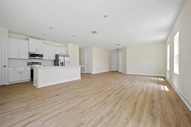 3779 Clearfield St, North Port, FL 34286 - unfurnished living room with visible vents, light wood-style floors, and baseboards