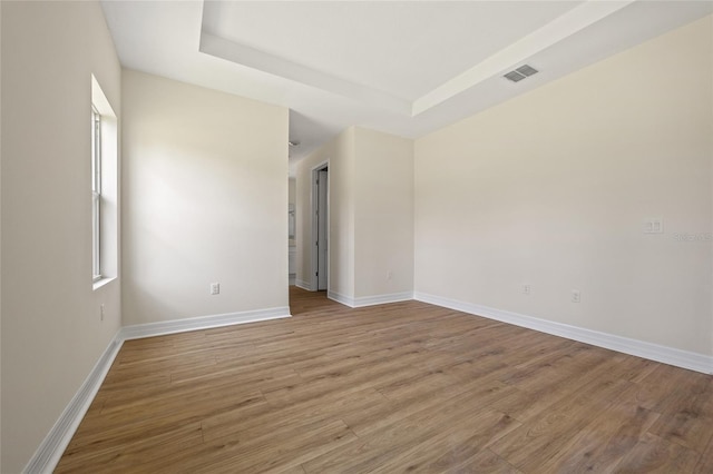 3779 Clearfield St, North Port, FL 34286 - empty room with a raised ceiling, baseboards, wood finished floors, and visible vents