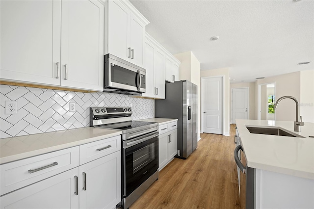 3779 Clearfield St, North Port, FL 34286 - kitchen with decorative backsplash, light countertops, white cabinetry, a sink, and stainless steel appliances