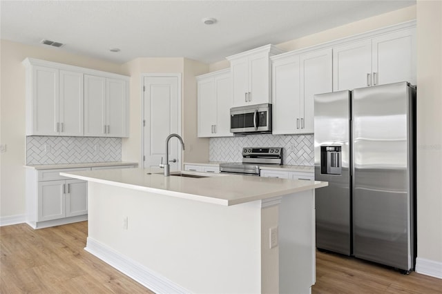 3779 Clearfield St, North Port, FL 34286 - kitchen with visible vents, a center island with sink, tasteful backsplash, a sink, and stainless steel appliances