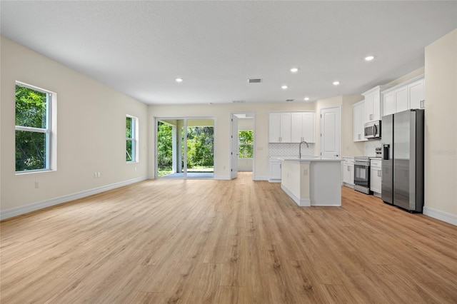 1415 Nackman Rd, North Port, FL 34288 - kitchen with appliances with stainless steel finishes, open floor plan, white cabinets, plenty of natural light, and recessed lighting