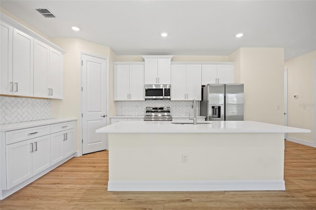 1415 Nackman Rd, North Port, FL 34288 - kitchen featuring stainless steel appliances, a sink, a center island with sink, white cabinetry, and recessed lighting