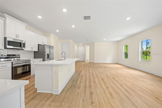 1415 Nackman Rd, North Port, FL 34288 - kitchen featuring appliances with stainless steel finishes, a sink, light wood-type flooring, backsplash, and recessed lighting