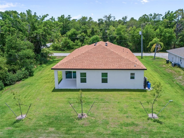 1415 Nackman Rd, North Port, FL 34288 - rear view of house featuring stucco siding, a yard, a patio area, and a shingled roof