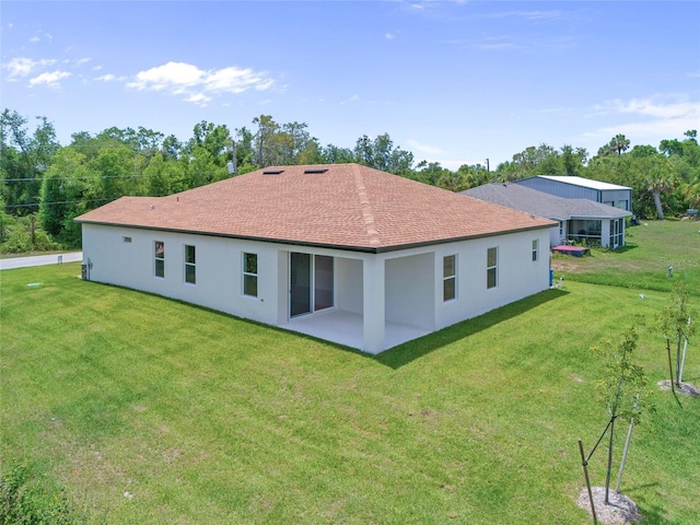 1415 Nackman Rd, North Port, FL 34288 - back of house featuring a lawn, a patio, stucco siding, and roof with shingles