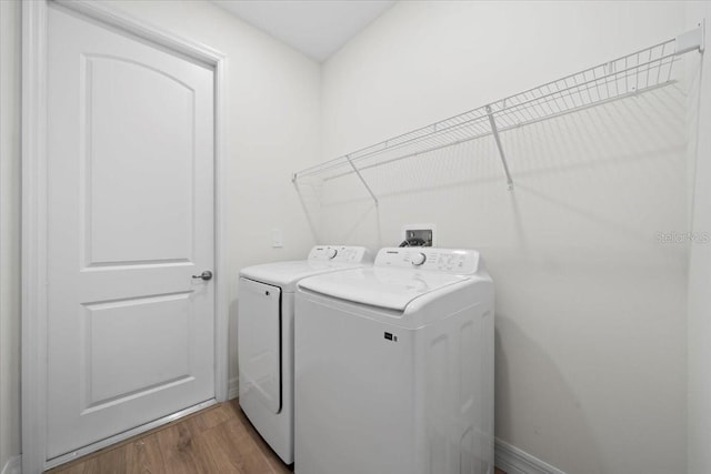 washroom with washing machine and dryer and wood-type flooring