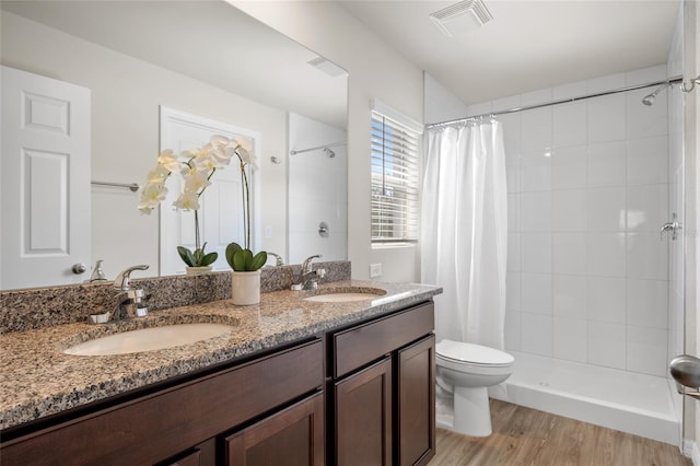 bathroom with toilet, vanity, hardwood / wood-style floors, and walk in shower