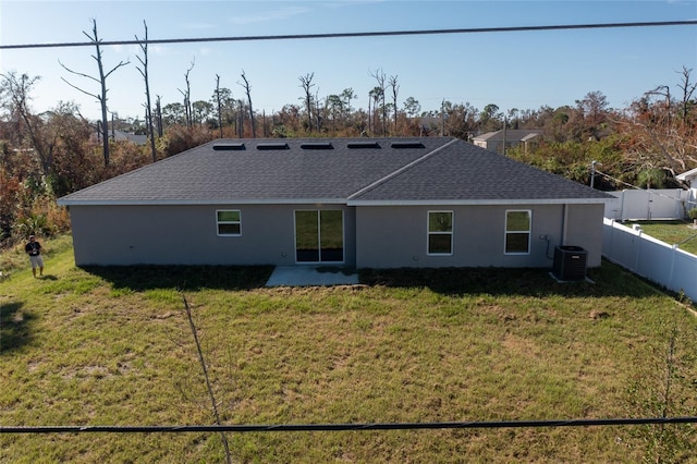 rear view of property with a patio, central AC, and a yard