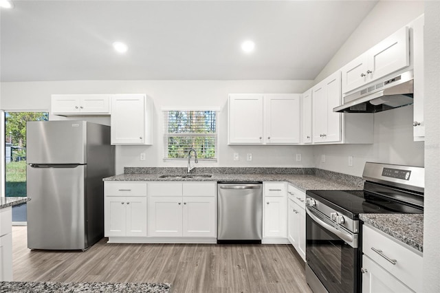 kitchen featuring appliances with stainless steel finishes, sink, white cabinets, light hardwood / wood-style floors, and lofted ceiling