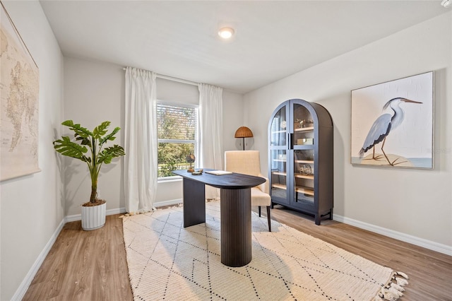 home office with light hardwood / wood-style flooring