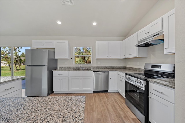 kitchen with light wood-type flooring, stainless steel appliances, sink, white cabinetry, and lofted ceiling