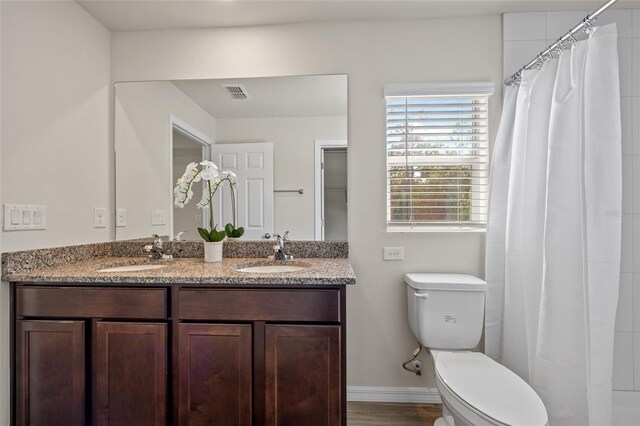 bathroom with a shower with shower curtain, hardwood / wood-style flooring, vanity, and toilet