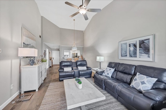 living room featuring hardwood / wood-style flooring, high vaulted ceiling, and ceiling fan