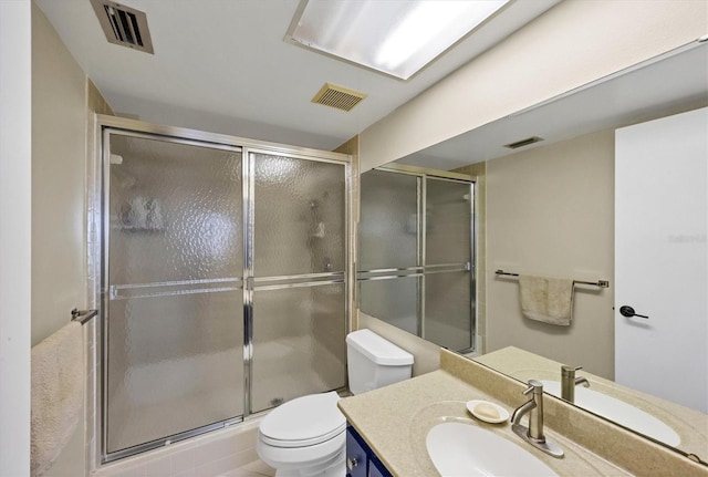 bathroom featuring toilet, an enclosed shower, and vanity