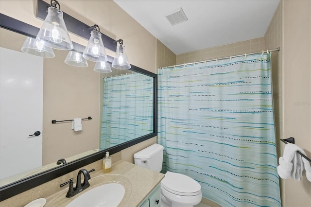 bathroom featuring toilet, curtained shower, and vanity