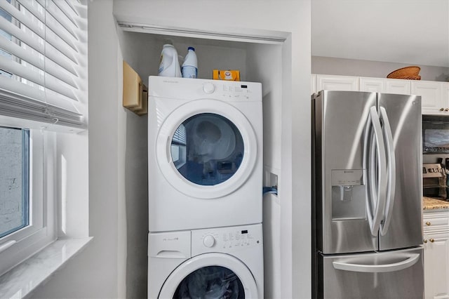 washroom featuring stacked washer / drying machine