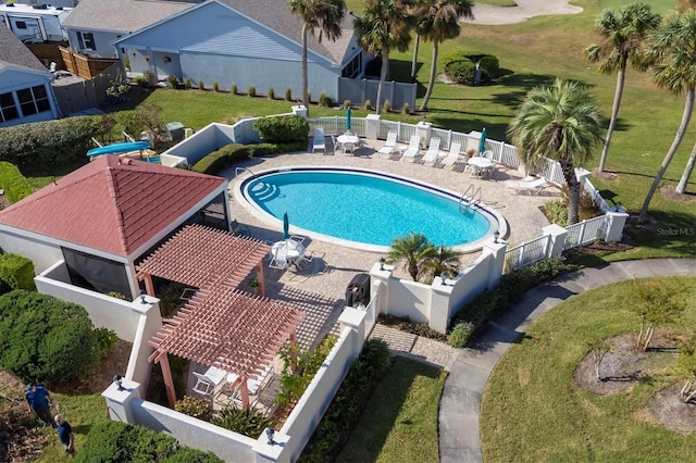 view of pool with a patio and a lawn