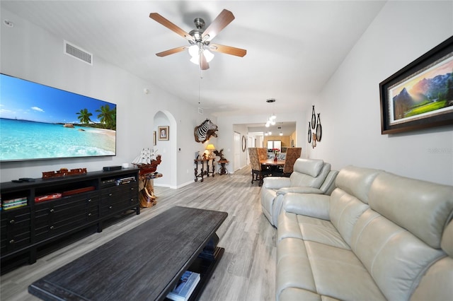 living room featuring light hardwood / wood-style floors and ceiling fan with notable chandelier