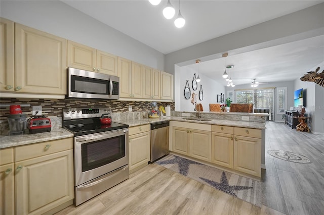 kitchen featuring light wood-type flooring, pendant lighting, appliances with stainless steel finishes, and kitchen peninsula