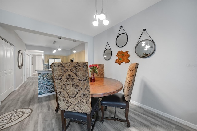 dining area with light wood-type flooring and a chandelier