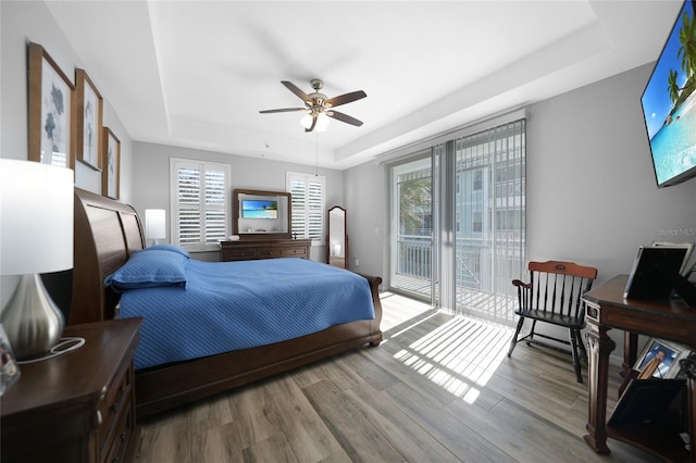 bedroom featuring hardwood / wood-style flooring, a raised ceiling, and ceiling fan